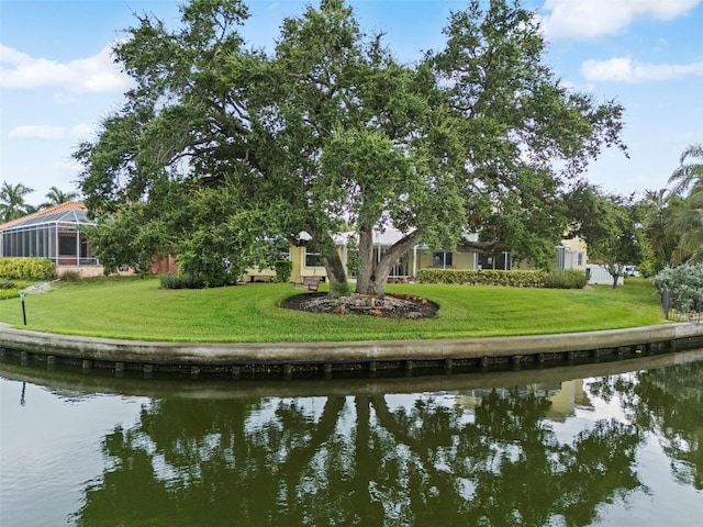 back of property with a lawn and a water view