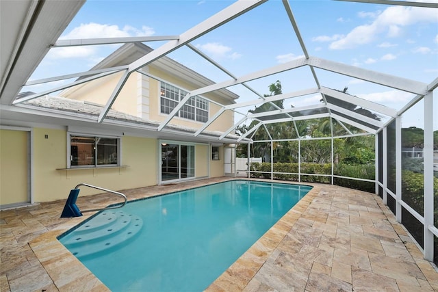 view of pool with glass enclosure and a patio area