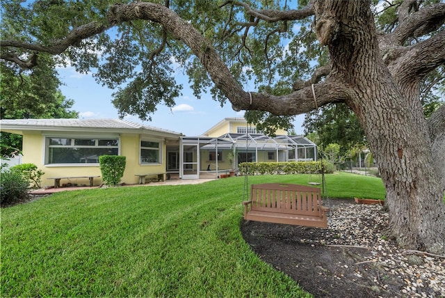 back of house with a yard and a lanai