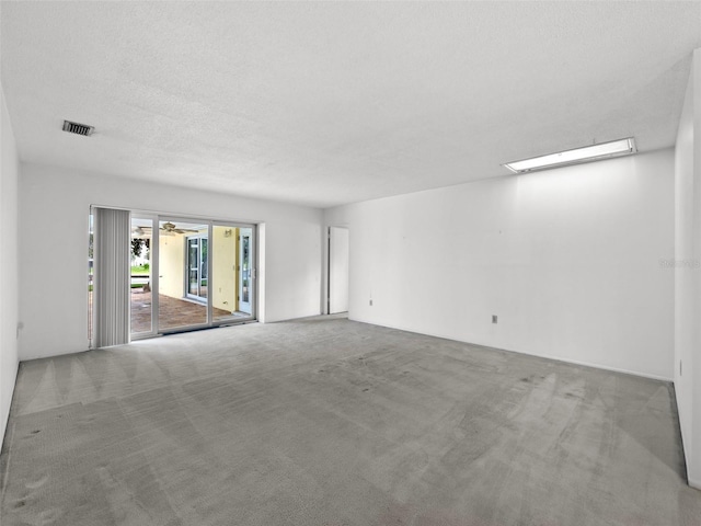 carpeted empty room featuring a textured ceiling