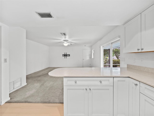 kitchen featuring ceiling fan, kitchen peninsula, light hardwood / wood-style flooring, and white cabinets