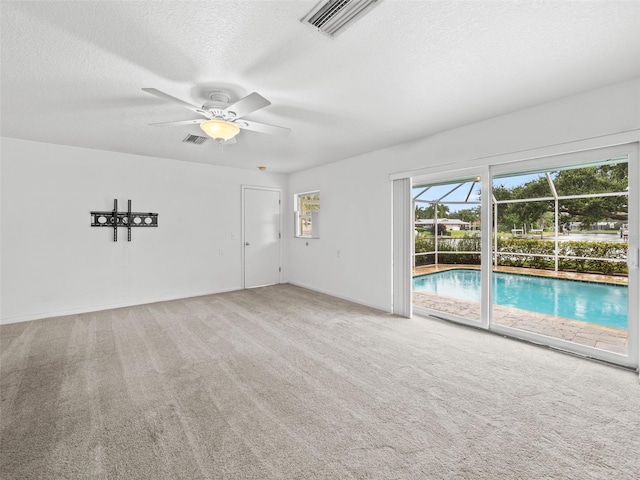 carpeted empty room with a textured ceiling and ceiling fan