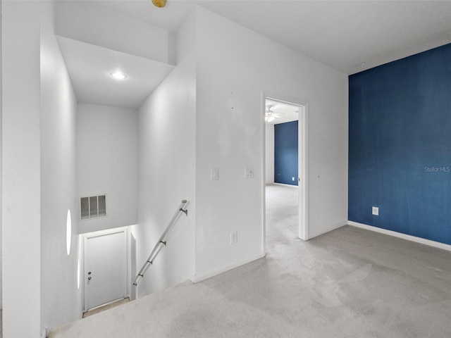 carpeted spare room featuring ceiling fan