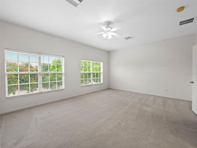 carpeted spare room featuring ceiling fan