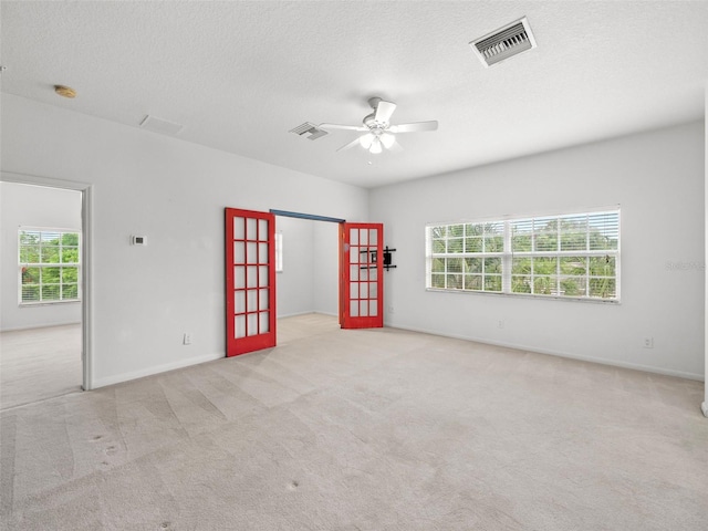 carpeted spare room featuring a textured ceiling and ceiling fan