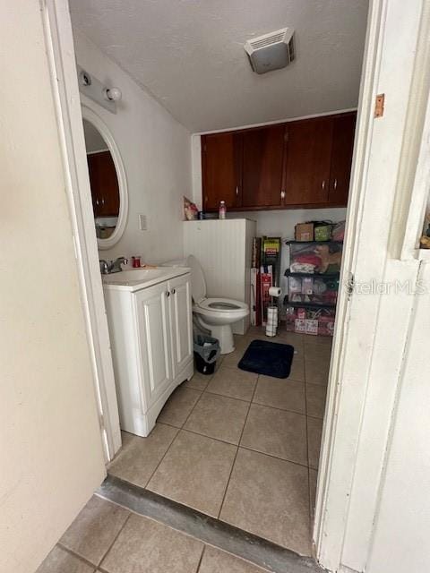 bathroom featuring vanity, toilet, and tile patterned floors