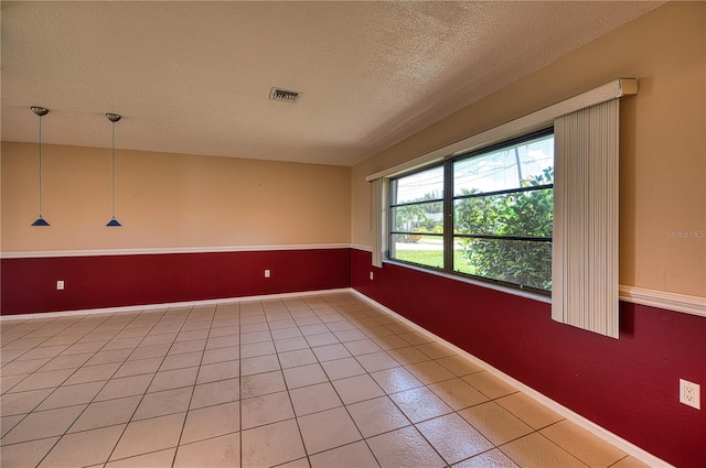 tiled spare room with a textured ceiling