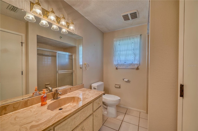 bathroom featuring toilet, a textured ceiling, tile patterned flooring, an enclosed shower, and vanity