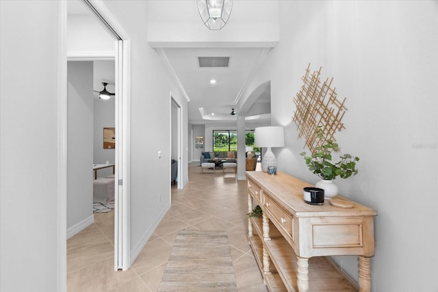 hallway featuring ornamental molding and light tile patterned floors