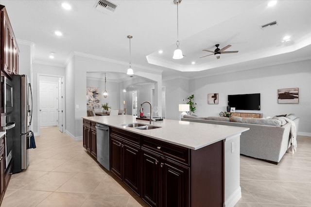 kitchen with pendant lighting, sink, ornamental molding, a kitchen island with sink, and stainless steel dishwasher