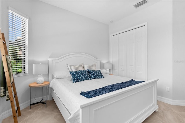 bedroom featuring multiple windows, a closet, and light tile patterned flooring