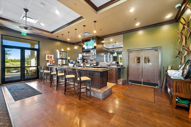 bar with crown molding, dark hardwood / wood-style floors, pendant lighting, and french doors