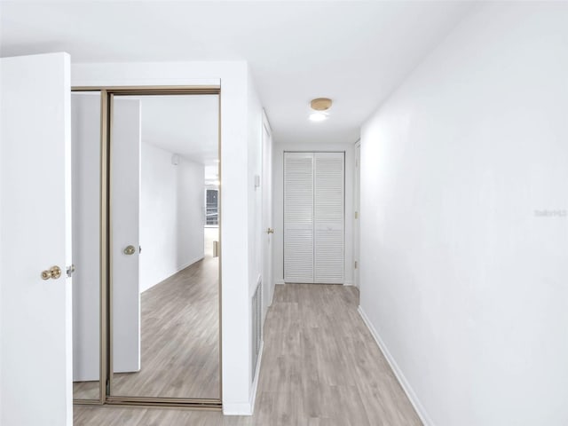 hallway with light hardwood / wood-style flooring