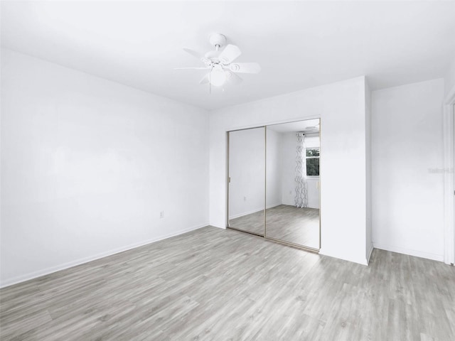 unfurnished bedroom with light hardwood / wood-style floors, a closet, and ceiling fan