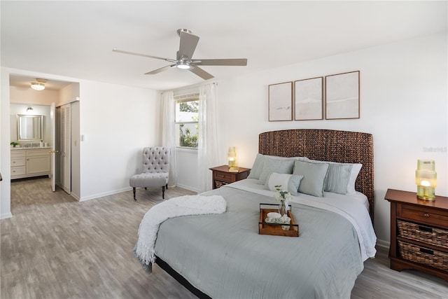 bedroom featuring ceiling fan, ensuite bath, a closet, and light wood-type flooring