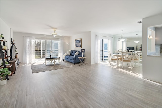 living room with ceiling fan and light wood-type flooring