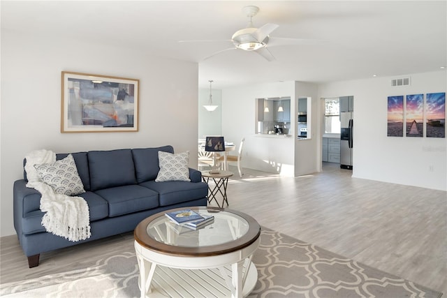 living room featuring hardwood / wood-style flooring and ceiling fan