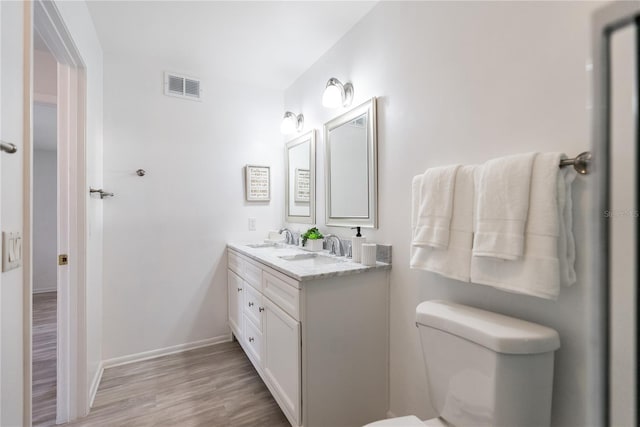 bathroom featuring vanity, wood-type flooring, and toilet