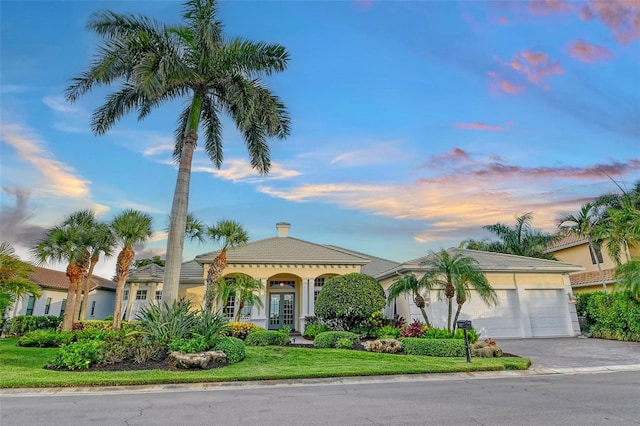 mediterranean / spanish-style home with a garage and french doors