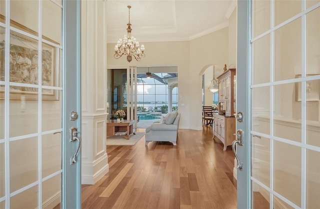 entrance foyer featuring crown molding, hardwood / wood-style floors, and an inviting chandelier