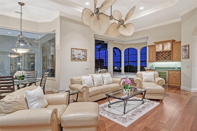 living room featuring wine cooler, wet bar, hardwood / wood-style floors, and ornamental molding