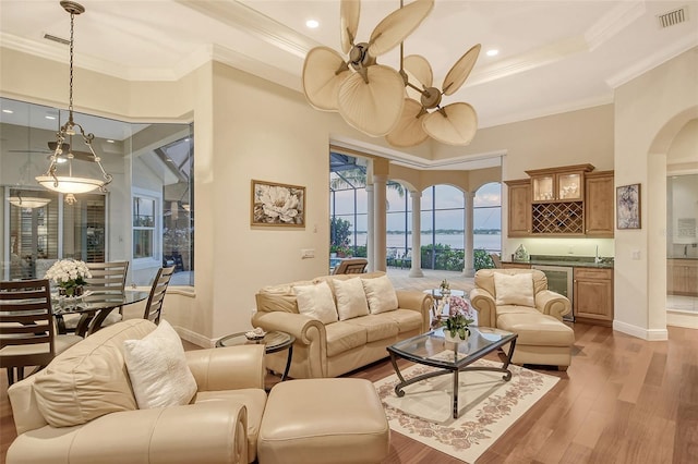 living room with ceiling fan, light hardwood / wood-style floors, and ornamental molding