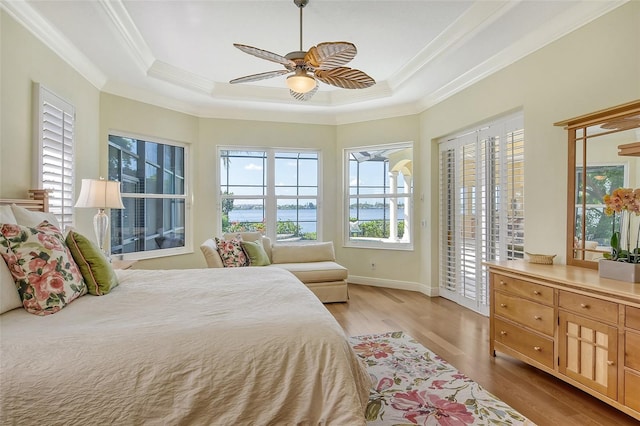 bedroom featuring access to outside, a raised ceiling, ceiling fan, and light hardwood / wood-style flooring