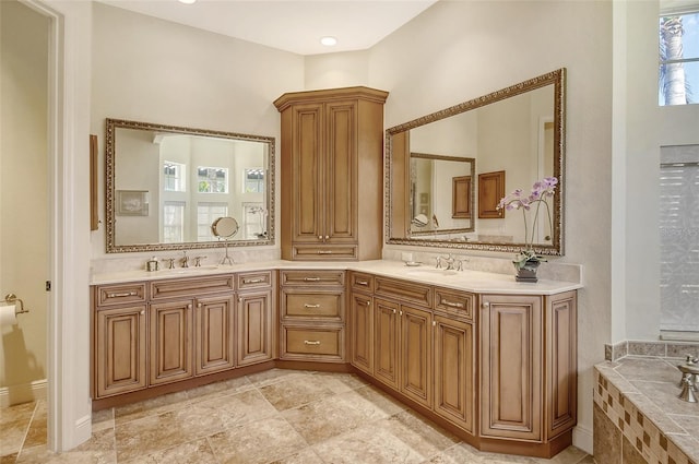 bathroom featuring tiled bath and vanity