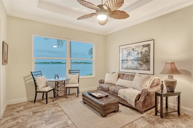 living room featuring ceiling fan, a water view, and crown molding