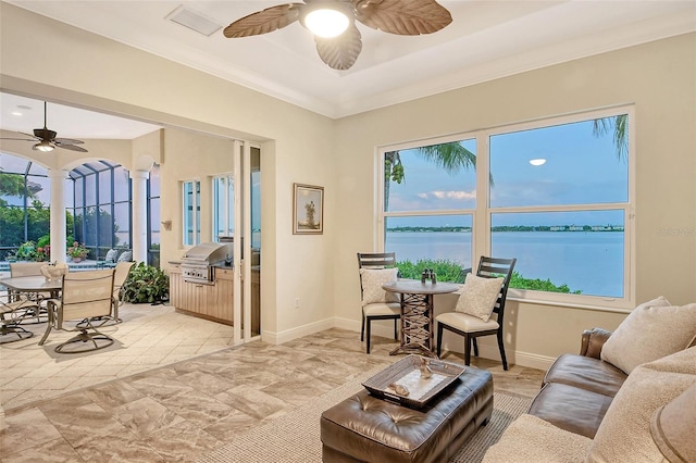 living room with ceiling fan, a water view, and ornamental molding