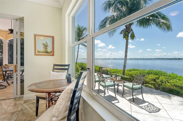 sunroom featuring a water view