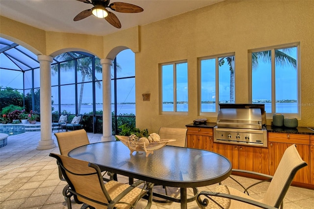 dining space with ceiling fan and a water view