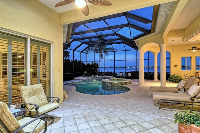 view of swimming pool featuring an in ground hot tub, a patio, glass enclosure, and ceiling fan