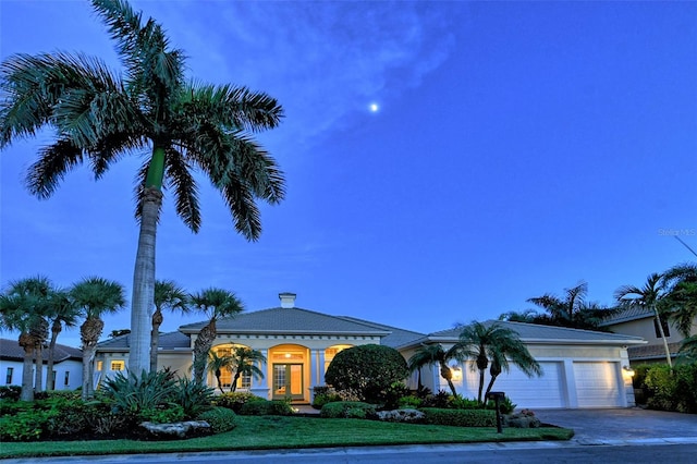 view of front facade with a garage and a yard