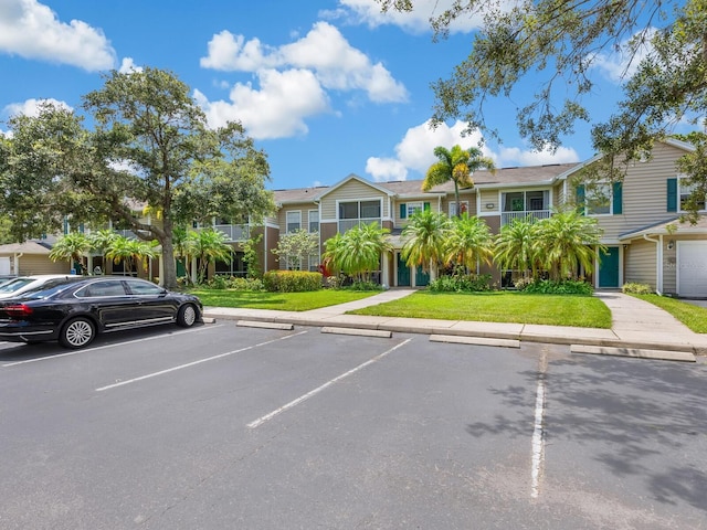 view of parking / parking lot with a garage and a yard