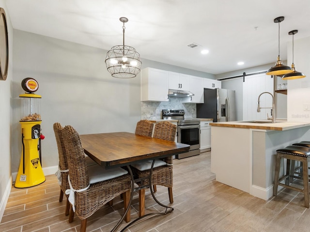 dining area with a barn door and sink