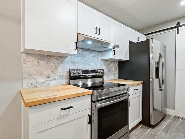 kitchen with wood counters, white cabinetry, tasteful backsplash, stainless steel appliances, and a barn door