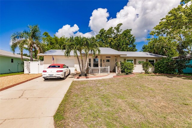 ranch-style house with a garage, a porch, and a front lawn