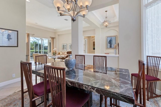 tiled dining area featuring baseboards, ornamental molding, and an inviting chandelier