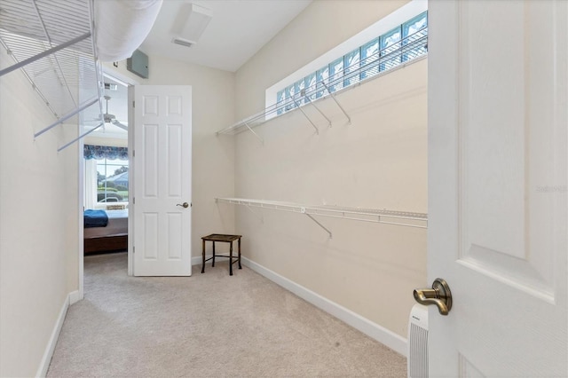 walk in closet featuring visible vents and light colored carpet