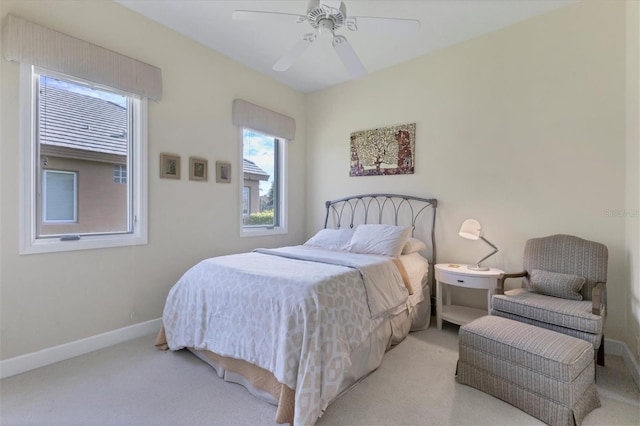 bedroom featuring a ceiling fan, light carpet, and baseboards