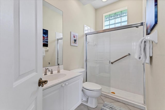 bathroom featuring a stall shower, tile patterned flooring, vanity, and toilet