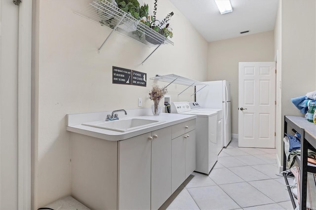 laundry room featuring cabinet space, light tile patterned floors, visible vents, washer and clothes dryer, and a sink