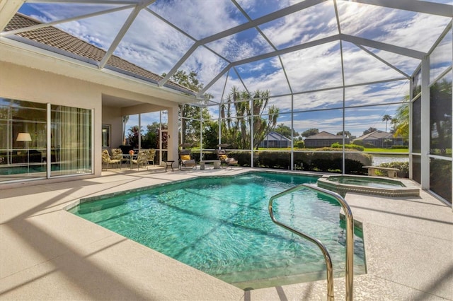 view of pool featuring glass enclosure, a patio, a water view, and a pool with connected hot tub