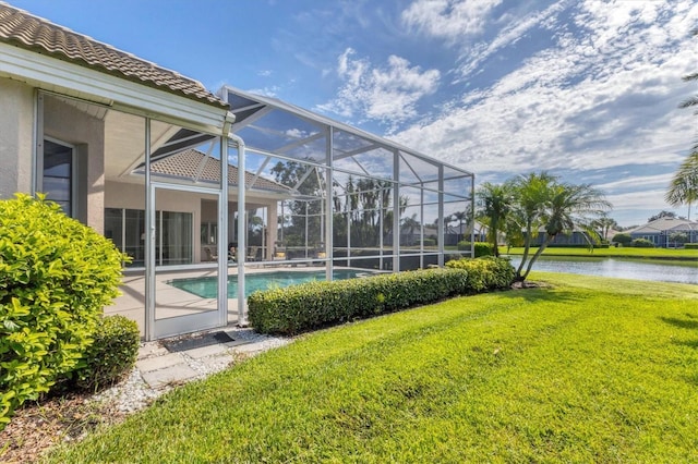 outdoor pool with a lawn, a water view, and a lanai