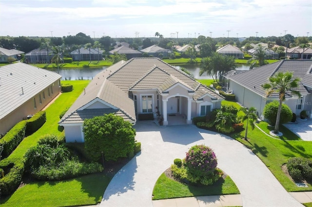 view of front of house with a residential view, decorative driveway, a tile roof, and a water view