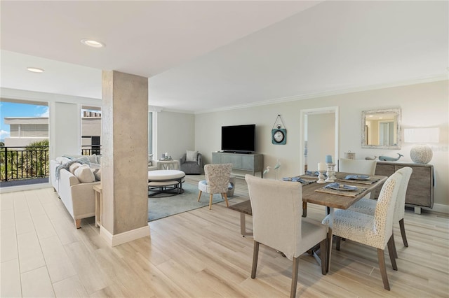 dining area with decorative columns, ornamental molding, and light wood-type flooring