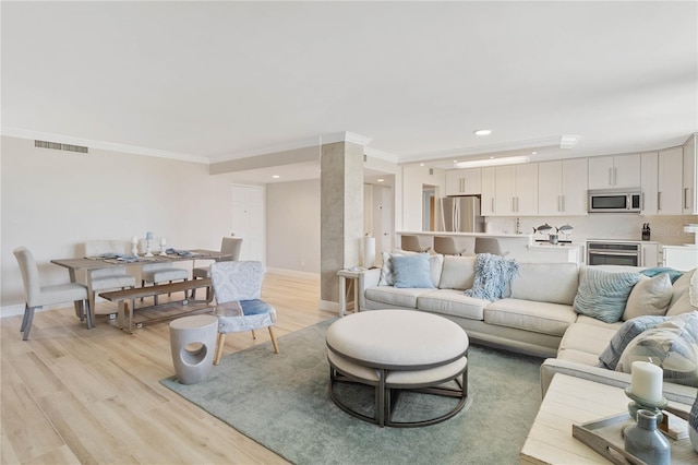 living room featuring crown molding and light hardwood / wood-style flooring