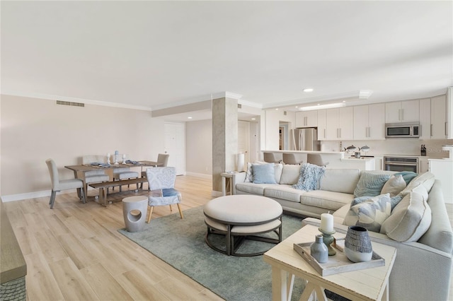 living room featuring ornamental molding and light hardwood / wood-style floors