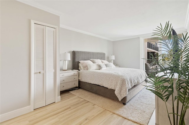 bedroom with light wood-type flooring, a closet, and ornamental molding